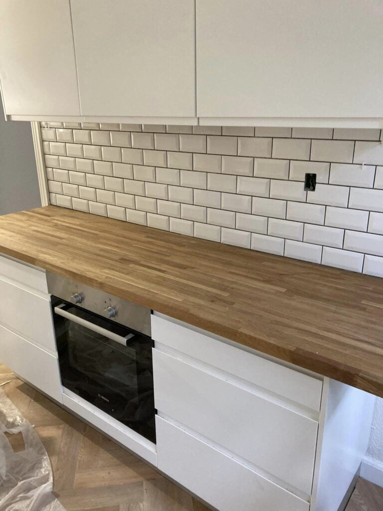 Moderne køkken med hvide skabe og træbordplade